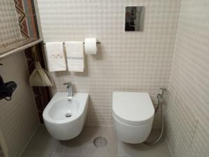 a white bathroom with a toilet and a sink at MEA DOMUS Mergellina in Naples