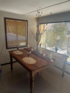 a wooden table in a room with two windows at THE TREE HOUSE in Grabouw