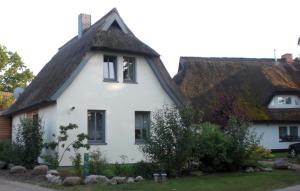 ein weißes Haus mit einem Strohdach in der Unterkunft Casa Manfredi in Prerow