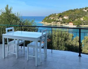 Biały stół i krzesła na balkonie z widokiem na ocean w obiekcie Studio Upper Lina w mieście Lákka