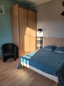 1 dormitorio con 1 cama y 1 silla negra en Appartement meublé rénové idéal pour curistes ou vacanciers, en La Roche-Posay