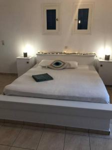sypialnia z dużym białym łóżkiem i oknem w obiekcie Beach House in Ios Cyclades w mieście Tzamaria