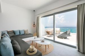 a living room with a couch and a large window at Seanfinity Beachfront Suites in Mikri Vigla