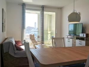 uma sala de estar com uma mesa, um sofá e uma televisão em Izzy&Simple em Split