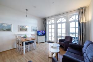 a living room with a couch and a table and a dining room at Nordland Appartements - Wohnung Nordstrand in Wyk auf Föhr