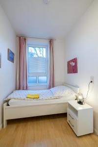 - une chambre avec un grand lit et une fenêtre dans l'établissement Nordland Appartements - Wohnung Nordstrand, à Wyk auf Föhr