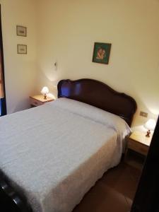 een slaapkamer met een groot bed met 2 nachtkastjes bij Nico 12 in Santa Luria