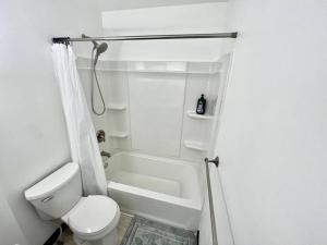 a white bathroom with a toilet and a shower at NEW! Remodeled Stow/Cuyahoga Falls Home! in Stow
