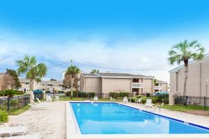 a swimming pool with chairs and a house at Chateau La Mer 2A in Destin