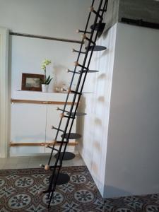 - un escalier en colimaçon dans un salon avec une étagère dans l'établissement MEA DOMUS Mergellina, à Naples