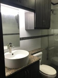 a bathroom with a white sink and a toilet at Rare 1BR condo, Makati Philippines in Manila