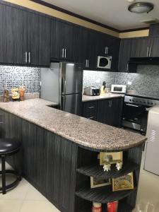 a kitchen with black cabinets and a granite counter top at Rare 1BR condo, Makati Philippines in Manila
