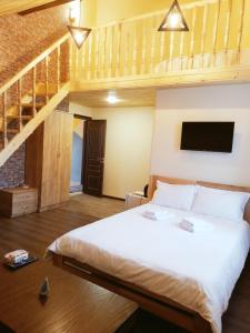a bedroom with a large bed and a staircase at NOY Guest House B&B in Vanadzor