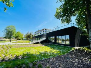 une maison moderne avec une façade noire dans l'établissement Apartament Słoneczny Dziwnów, à Dziwnów