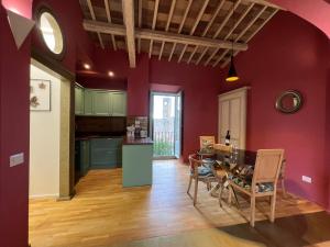 a kitchen and dining room with red walls and a table at Cathedral House Orvieto in Orvieto