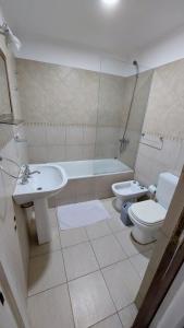 ein Badezimmer mit Waschbecken, Toilette und Badewanne in der Unterkunft Miras Del Mar in Puerto Madryn + 12 Fotos