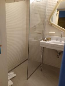 La salle de bains est pourvue d'un lavabo et d'une douche. dans l'établissement MEA DOMUS Mergellina, à Naples