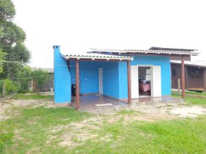 ein kleines blaues Haus in einem Hof in der Unterkunft Casa temporada praia da galheta 3 in Laguna