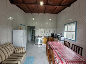 a kitchen with a refrigerator and a table in it at Casa temporada praia da galheta 3 in Laguna