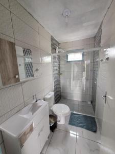 La salle de bains est pourvue de toilettes, d'un lavabo et d'une douche. dans l'établissement Casa temporada praia da galheta 3, à Laguna