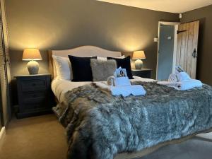 um quarto com uma cama grande com dois bichos de peluche em Meadow Cottage em Salisbury