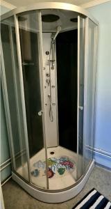 La salle de bains est pourvue d'une douche et d'une cabine de verre. dans l'établissement Mysig Lägenhet för resande., à Stocka