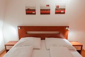 Ramzová Pod Klínem في أوستروزنا: سرير مع وسادتين وصورتين على الحائط
