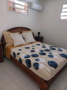 a bedroom with a bed with blue and white comforter at T2 cirique in Les Anses-dʼArlets