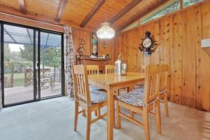 ein Esszimmer mit einem Holztisch und Stühlen in der Unterkunft Rustic cottage on Canal Lake in Carden