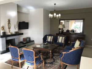 - un salon avec des chaises bleues et une table basse dans l'établissement Villa apartment with private garden near the beach, à Drepano