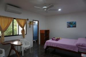 a bedroom with a bed and a ceiling fan at Hostal Suiza in Puerto Baquerizo Moreno