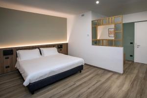 a bedroom with a large white bed and wooden floors at Moody smart & comfy Hotel in Terranuova Bracciolini
