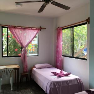 a bedroom with two beds and a ceiling fan at Hostal Suiza in Puerto Baquerizo Moreno