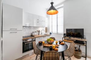a kitchen with a table with a bowl of fruit on it at HOME: Les richesses de Marseille à vos pieds! in Marseille