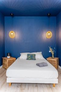 a blue bedroom with a white bed and two lamps at HOME: Les richesses de Marseille à vos pieds! in Marseille