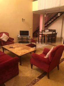 Propre appartement à loué pour les familles في مراكش: غرفة معيشة بها كنب وطاولة وبيانو