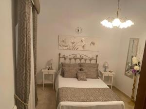 1 dormitorio con 1 cama, 2 mesas y lámpara de araña en Esencia Andalucia en Rociana