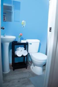 uma casa de banho com um WC branco e um lavatório. em JM GUESTHOUSE em Santo Domingo