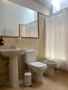 a bathroom with a sink and a toilet and a mirror at Hostería La Celestina in Tilcara