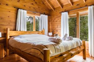 a bedroom with a bed in a log cabin at BOG Ocrehue - Cabanas in Villa La Angostura