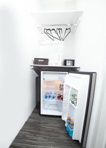 um pequeno frigorífico com a porta aberta num quarto em JM GUESTHOUSE em Santo Domingo