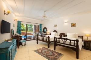 um quarto com duas camas e uma televisão em Storii By ITC Hotels, Shanti Morada Goa em Calangute