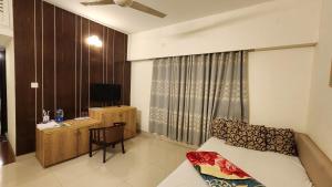 a room with a bed and a desk with a television at Hotel Cox Rotana in Cox's Bazar +12 photos