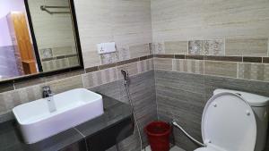 a bathroom with a sink and a toilet and a mirror at Hotel Cox Rotana in Cox's Bazar