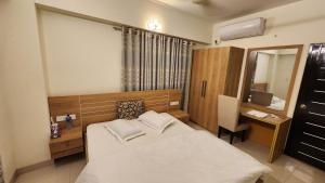 a bedroom with a bed and a desk and a mirror at Hotel Cox Rotana in Cox's Bazar