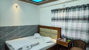 a bedroom with a bed and a table with a chair at Hotel Cox Rotana in Cox's Bazar