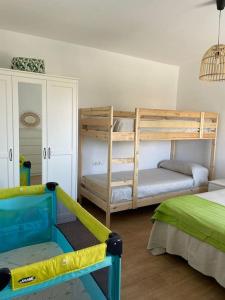 a bedroom with two bunk beds and a chair at El rincón del cabo! in Almería