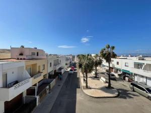 uma rua da cidade com palmeiras e edifícios em El rincón del cabo! em Almería
