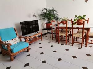 a living room with a table and chairs and a tv at El rincón del cabo! in Almería