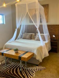 a bedroom with a bed with mosquito netting at Doornkom in Marloth Park